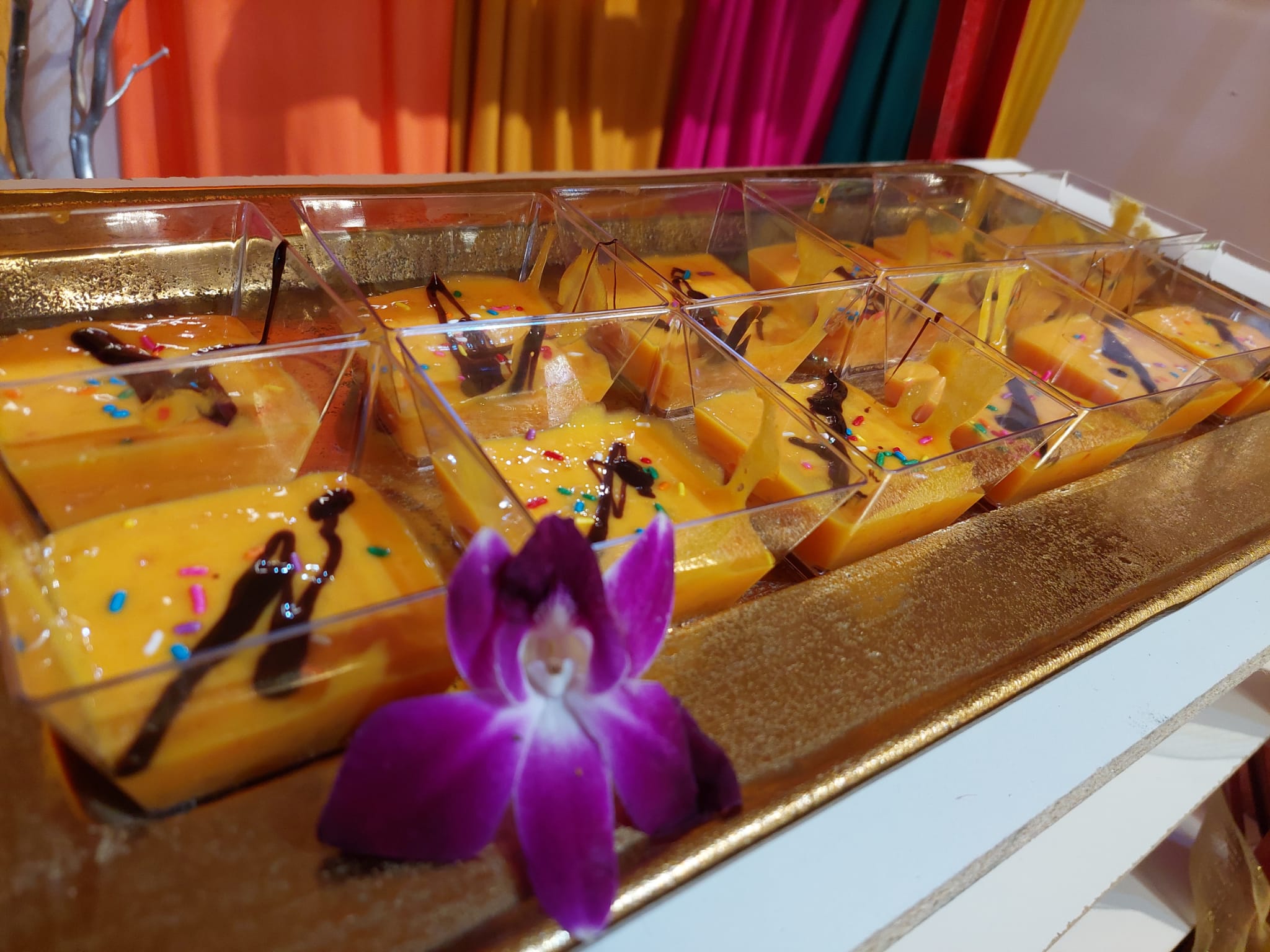 Mango dessert cups garnished with an orchid